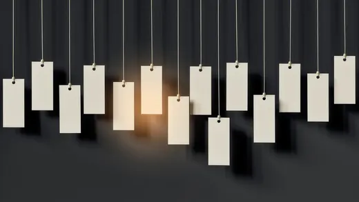 Blank paper tags hanging from thin wires, one glowing warm
