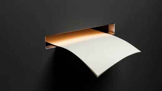 A blank sheet emerging from a glowing slot in a dark wall