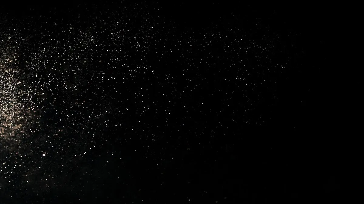 Captivating image of particles scattered across a dark backdrop, evoking a cosmic or dust effect.