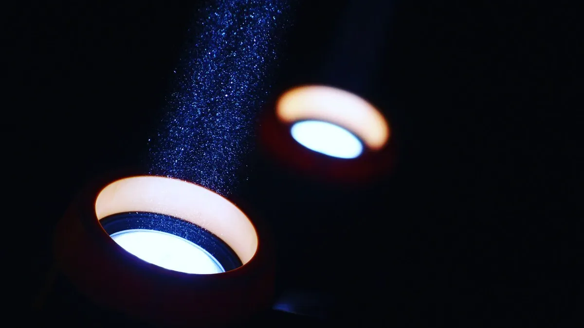 A striking visual of light beams illuminating particles in a dark setting, creating an abstract effect.
