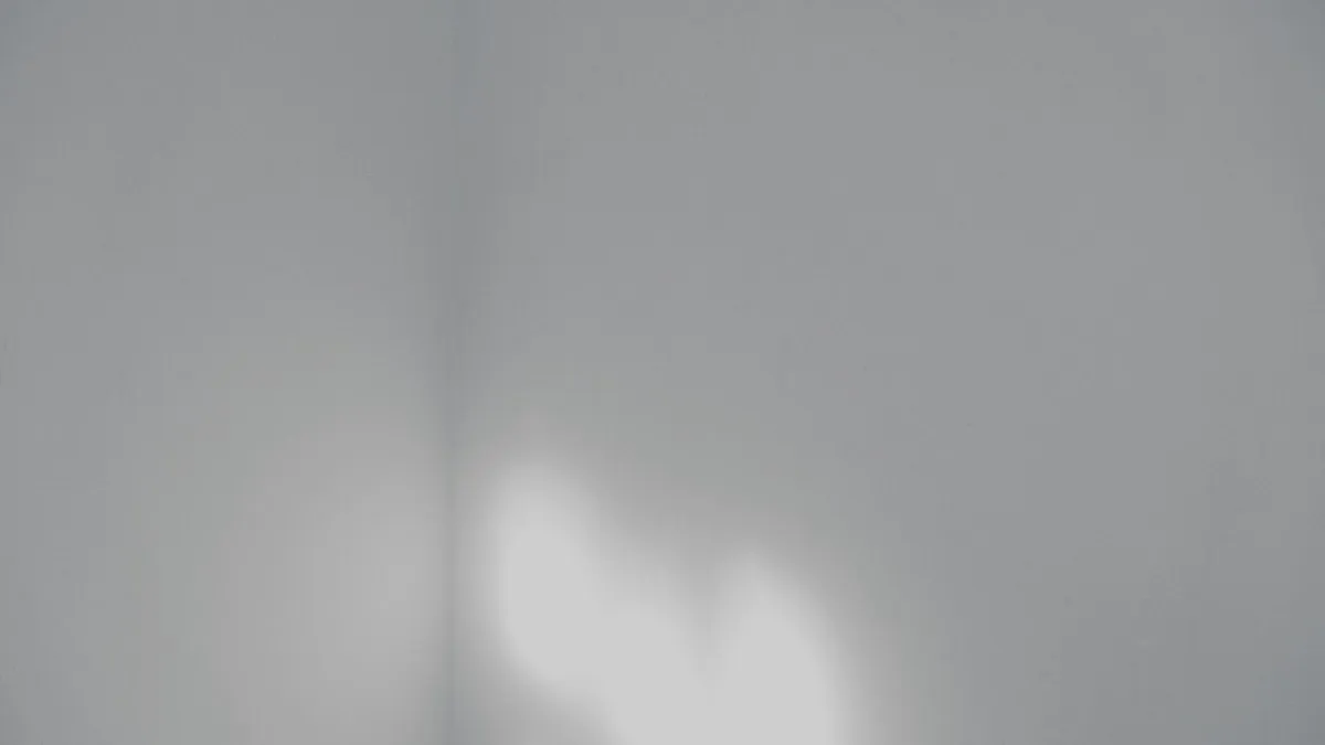 Abstract minimalist white wall with soft lighting, ideal for backgrounds.