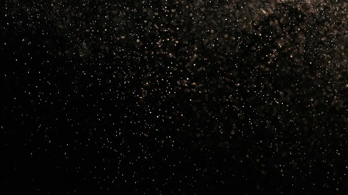 Mystical black texture with floating dust particles creating an abstract effect.